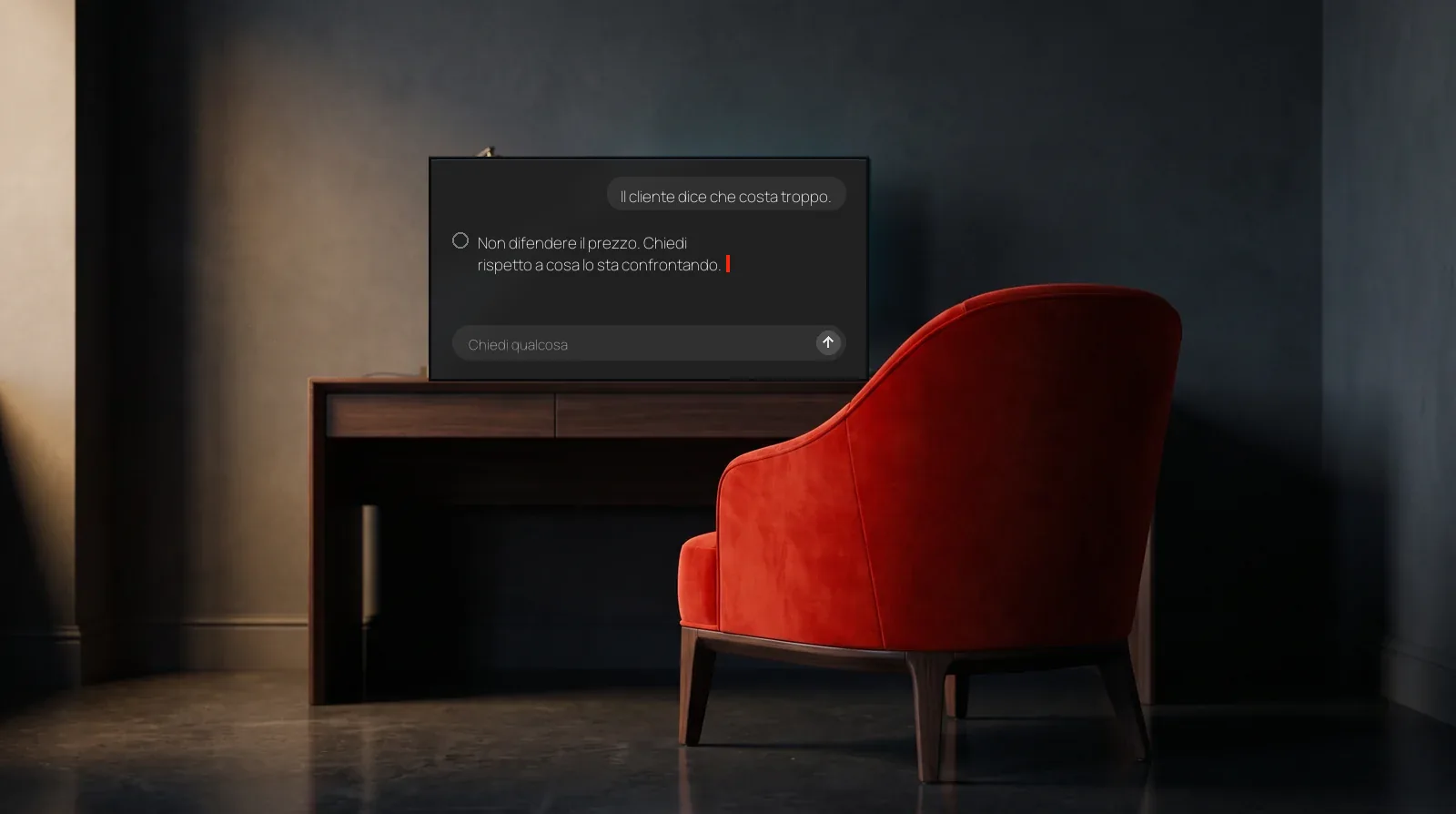 Una poltrona rossa davanti a una scrivania con uno schermo acceso su una chat con un assistente AI